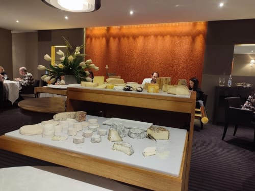 Dégustation de fromages à la boutique-hôtel Les Terrasses Dorées à Châtillon, France avec fromages artisanaux et décor floral