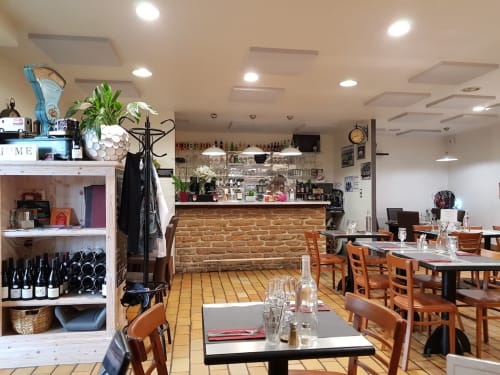 La salle à manger des Terrasses Dorées à Châtillon avec tables en bois, comptoir de bar et ambiance chaleureuse