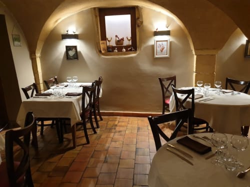 Salle à manger élégante aux Terrasses Dorées avec plafond voûté, tables dressées et éclairage chaleureux