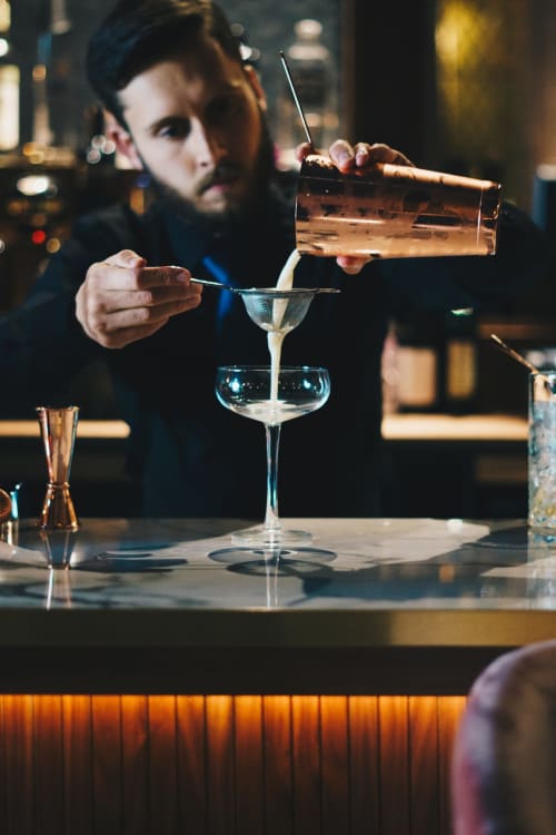 Pouring a cocktail in a bar.