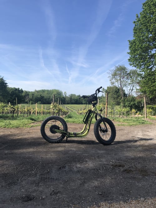 Vélo cargo électrique garé sur un chemin de vignoble aux Logis des Tourelles, Cognac, France