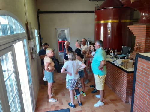 Visite guidée à la cave Logis des Tourelles à Cognac avec des visiteurs rassemblés dans la salle de dégustation