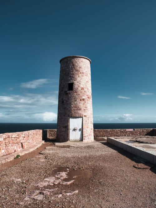 Tour historique en briques avec porte blanche surplombant la mer, fortification côtière de Dinan