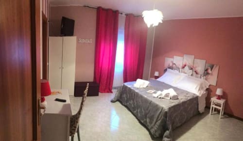 Accogliente camera Stella presso RL GROUP B&B Isernia: muri rosa, TV, scrivania e comfort moderni