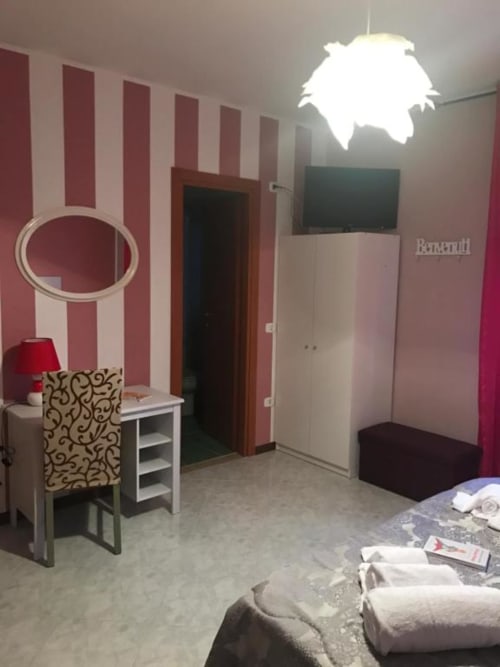 Camera moderna presso B&B Isernia con pareti a righe bordeaux, TV a schermo piatto, scrivania con lampada e arredi contemporanei