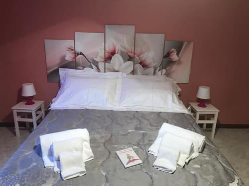 Camera elegante presso RL GROUP B&B a Isernia con pareti rosa, testata floreale, cuscini bianchi e comodini con lampade
