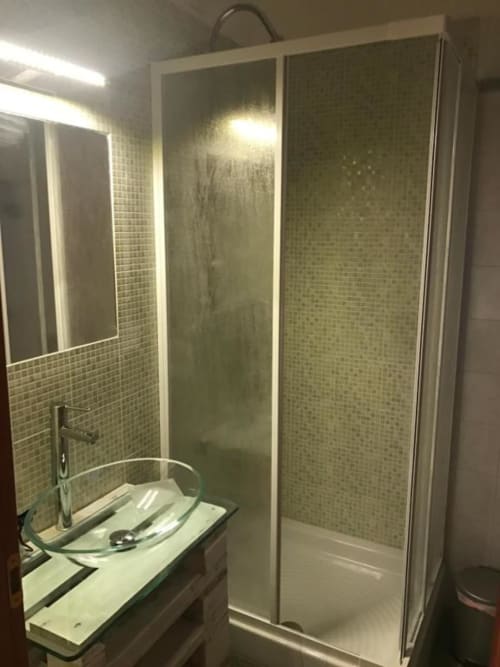 Moderna cabina doccia con porte in vetro e pareti in piastrelle verdi nella camera Stella di RL GROUP bnb, Isernia