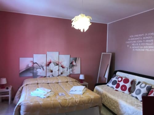 Accogliente camera con pareti rosa, due letti, testiera floreale e comfort moderni nella Stella room del B&B di Isernia
