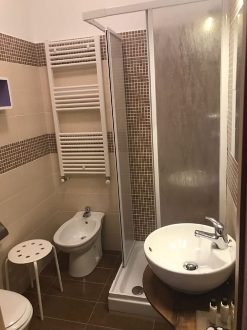 Moderno bagno con doccia in vetro, lavabo bianco, bidet e scaldasalviette nella RL GROUP B&B di Isernia