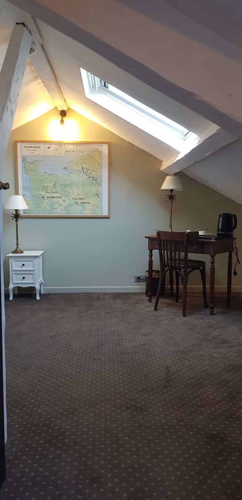Chambre mansardée confortable à L'Hôtel Les Cabines à Houlgate avec bureau, carte vintage, lucarne et mobilier d'époque