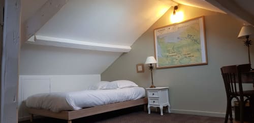 Chambre cosy sous les toits à l'hôtel Les Cabines à Houlgate avec lit simple, table de nuit blanche et carte marine murale