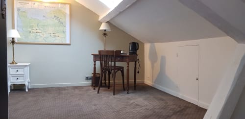 Chambre mansardée avec bureau, chaise et carte à l'hôtel Les Cabines à Houlgate, France