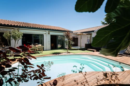 Piscine Villa Eden Bleu aux eaux turquoise, terrasse en bois et villa moderne blanche aux tuiles terracotta à Biscarrosse