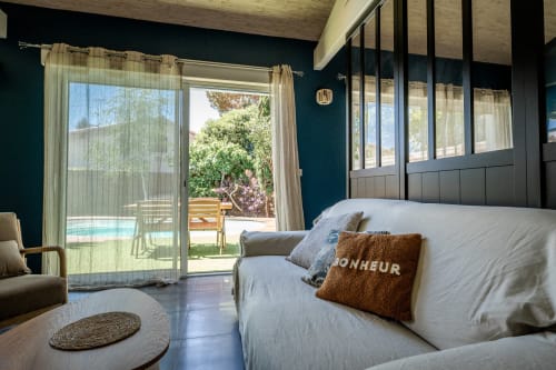 Chambre moderne à la Villa Eden Bleu à Biscarrosse avec vue sur piscine, lit, coin salon et portes-fenêtres accès terrasse