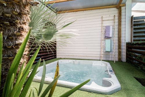 Bain à remous sur patio couvert avec palmiers et espace détente à la Villa Eden Bleu, Biscarrosse