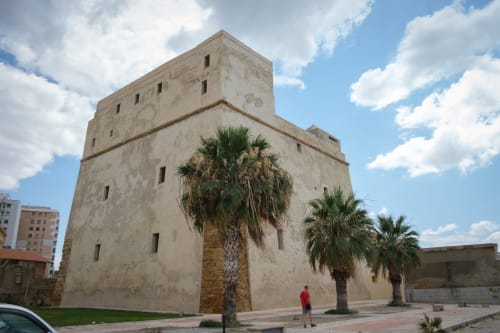 Torre in pietra storica con palme a Porto Empedocle, costa di Agrigento vicino a Stella Marina