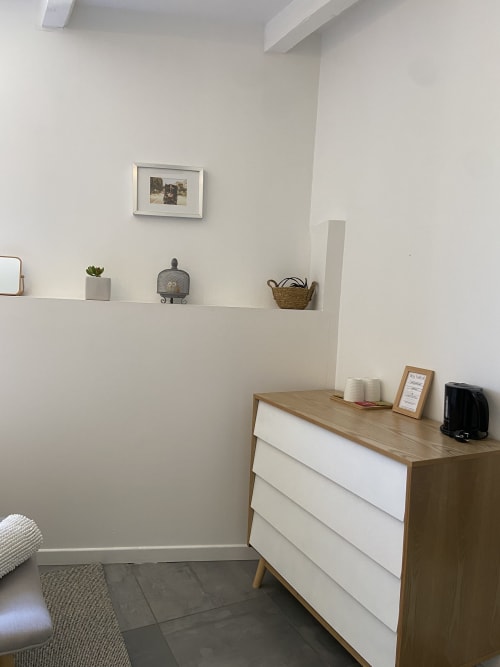 Elegantes Zimmer Mas Lafleur in Châteaurenard mit modernem Dekor, Holzkommode, weißen Wänden und schwebendem Regal