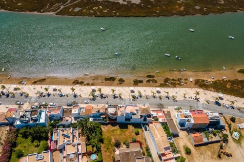Vista aérea da propriedade à beira-mar A Vida é Linda em Santa Luzia com águas turquesas, praia de areia e cores vibrantes