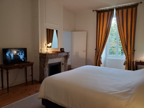 Chambre élégante au Logis des Tourelles B&B à Cognac avec cheminée, rideaux dorés et décoration classique