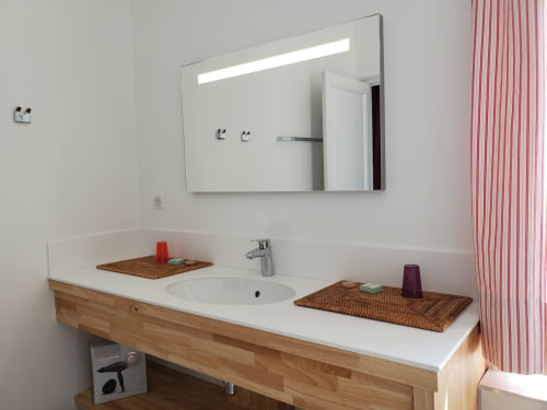 Lavabo moderne avec meuble en bois et miroir rétroéclairé au Logis des Tourelles B&B à Cognac