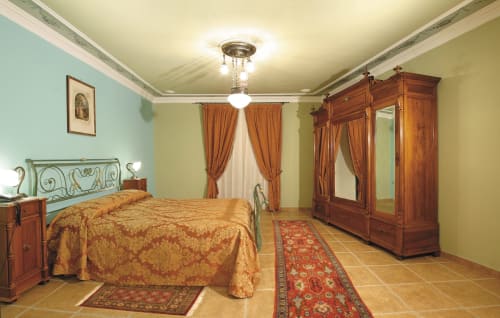 Elegante camera deluxe presso Locanda degli Illustri a Civitanova del Sannio con arredamenti in legno, letto ornato e stile classico