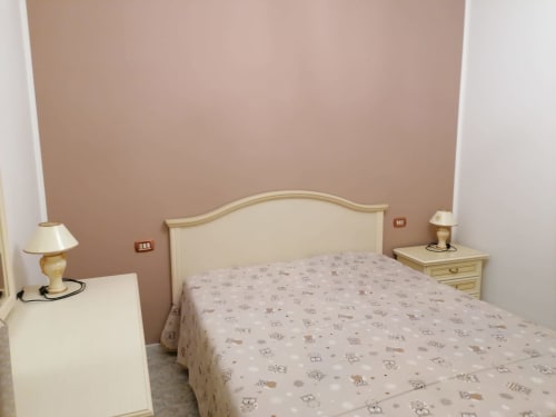 Camera accogliente nell'appartamento di Civitanova del Sannio con letto matrimoniale, testata in crema, comodini in legno e accenti in tonalità tortora
