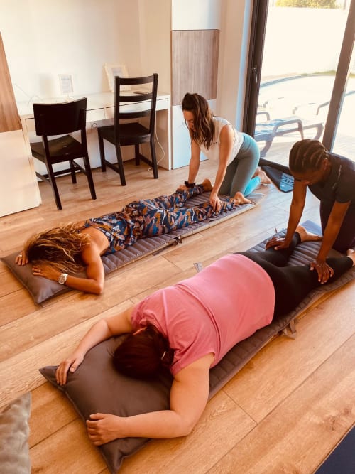 Instructrice de yoga guidant trois participants en posture de planche lors d'un cours bien-être à l'hôtel A Vida é Linda Santa Luzia