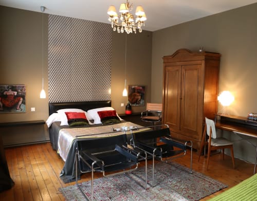 Chambre élégante du B&B Le Grand Duc à Valenciennes avec lustre, armoire en bois et mobilier moderne