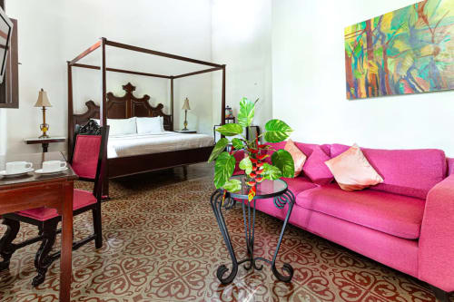 Una lujosa y acogedora vista de la habitación 2 en Villa Mérida, que muestra una cómoda cama king, un acogedor sofá y un área de escritorio bien equipada. La habitación emana una sensación de relajación y sofisticación con su elegante diseño. La pieza central es una espaciosa cama king adornada con suaves sábanas y almohadas de felpa, creando un refugio acogedor para los huéspedes. Junto a la cama, un cómodo sofá ofrece una zona de estar para relajarse o leer. También hay una elegante zona de escritorio, que ofrece un espacio exclusivo para trabajar o estudiar. La decoración de la habitación combina acentos de buen gusto, colores suaves y mucha luz natural, creando un ambiente sereno y acogedor. La habitación 2 de Villa Mérida está diseñada para ofrecer comodidad, estilo y funcionalidad, asegurando una estadía encantadora para los huéspedes