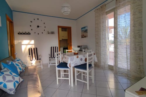 Zona pranzo dell'appartamento costiero luminoso a Stella Marina, Porto Empedocle con arredamento bianco e vista mare.
