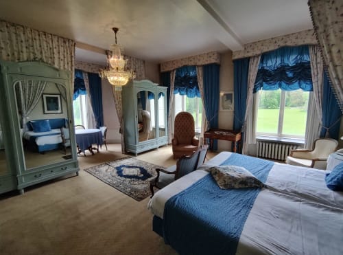 Suite Junior élégante au Château d'Hassonville avec accents bleus, vue sur le jardin et mobilier d'époque à Marche-en-Famenne