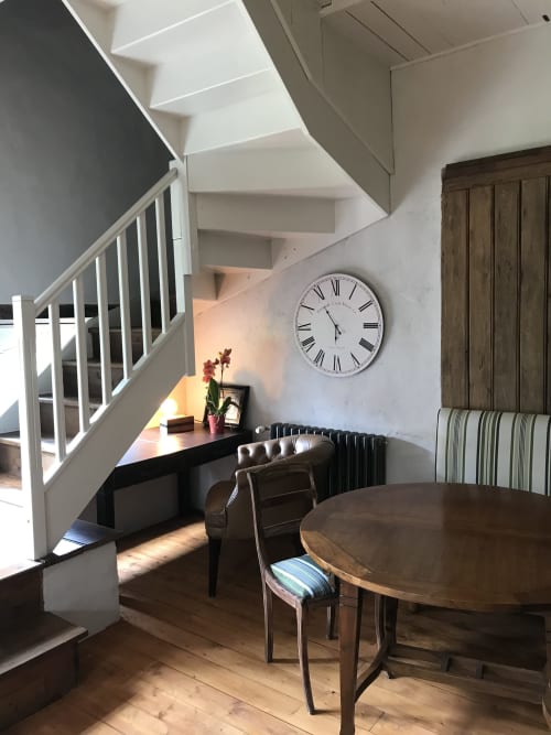 Intérieur élégant du Petit Manoir de Kériolet avec escalier en spirale, table ronde et bureau de travail