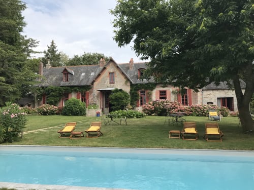 Le Petit Manoir de Kériolet, cottage avec vue piscine, bains de soleil jaunes sur pelouse, arbustes fleuris, Concarneau
