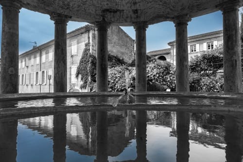 Classical colonnade with reflecting pool overlooking ivy-covered buildings at Le Pavillon M in Grignan