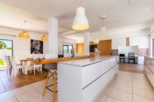 Cuisine ouverte moderne et salle à manger de la Villa A Vida é Linda avec luminaires suspendus blancs, table en bois et jardin