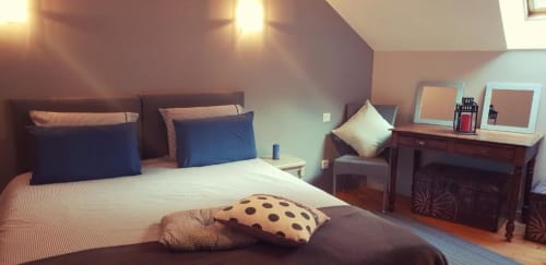 Chambre spacieuse du Gite de la Tannerie 2 à Dinan avec lit queen, oreillers bleus, coussin à pois et bureau en bois