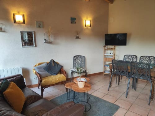 Salon lumineux à la villa avec sièges confortables, TV et vue sur le jardin à La Conciergerie à Dinan