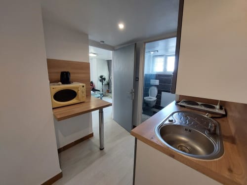 Kitchenette moderne avec évier en acier inoxydable, micro-ondes et plan de travail en bois à NancyRoom, Vandoeuvre-les-Nancy