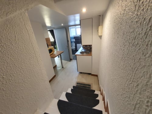 Couloir de l'appartement NancyRoom avec escalier, kitchenette et décoration moderne à Vandoeuvre-les-Nancy