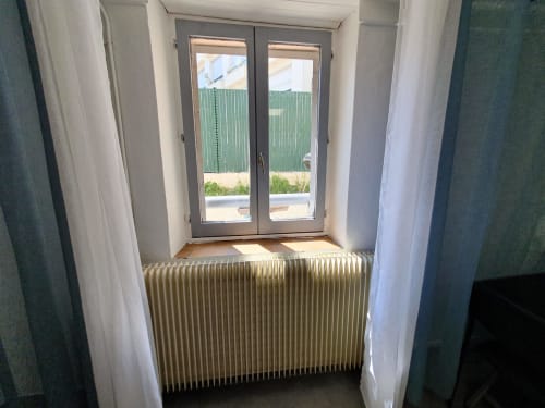 Entrée lumineuse à NancyRoom avec radiateur et portes vitrées donnant sur la cour de Vandoeuvre-les-Nancy