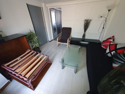 Salon moderne à Vandoeuvre-les-Nancy : canapé-lit, fauteuil, table en verre, bureau et vue sur la ville