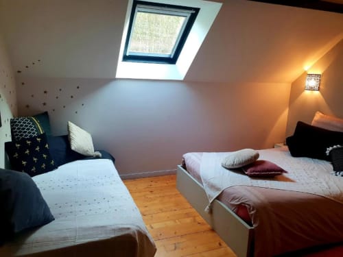 Chambre douillette sous les toits à la Gite de la Tannerie à Dinan avec deux lits, puits de lumière et ambiance chaleureuse