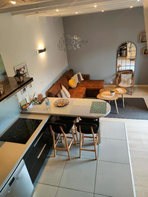 Cuisine ouverte et séjour contemporain du Gîte de la Tannerie à Dinan avec canapé marron, table à manger et inox