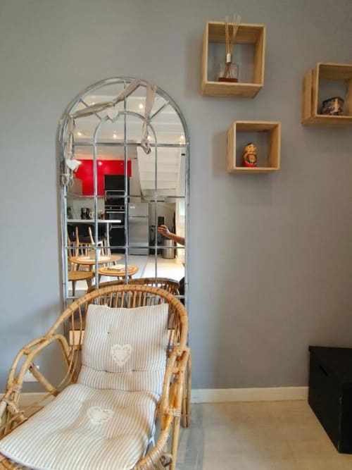 Chaise en rotin tissé avec coussin rayé à La Conciergerie de Nathalie, Dinan, miroir bombé et étagères en bois