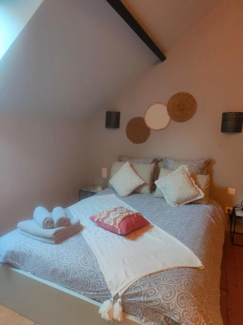 Chambre douillette à La Conciergerie de Nathalie, Dinan avec lit décoré, oreillers et décoration murale