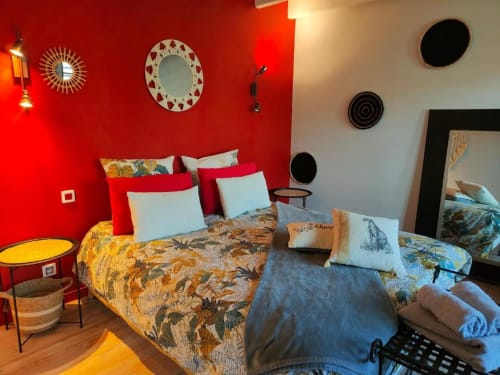 Chambre colorée à La Conciergerie de Nathalie, villa de Dinan aux murs rouges, literie à motifs, miroirs décor