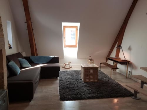 Appartement Ty Clement à La Conciergerie de Nathalie à Dinan, avec canapé noir, poutres en bois et lucarne