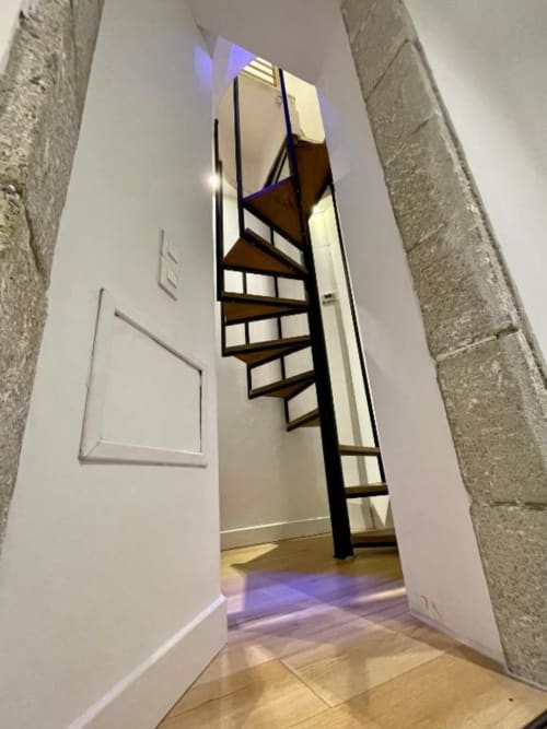 Escalier hélicoïdal dans un appartement duplex à La Conciergerie de Nathalie, Dinan, design contemporain et éclairage bleu