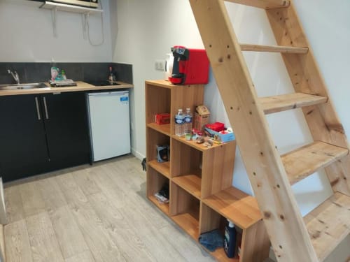 Kitchenette du Studio Hikoki avec cafetière rouge, étagères en bois et échelle de mezzanine à La Conciergerie, Dinan