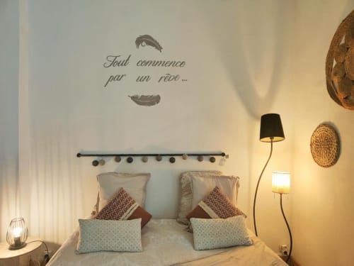 Chambre cosy à La Conciergerie de Nathalie à Dinan avec citation murale française, plumes décoratives et ambiance chaleureuse